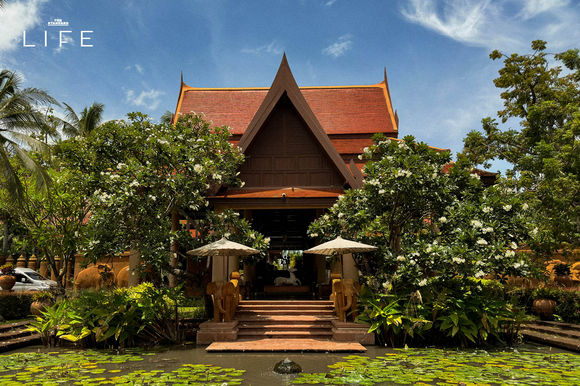 ภาพมุมกว้างของ Anantara Hua Hin Resort แสดงให้เห็นสระว่ายน้ำและอาคารทรงไทยที่ได้รับการปรับปรุงใหม่ 1