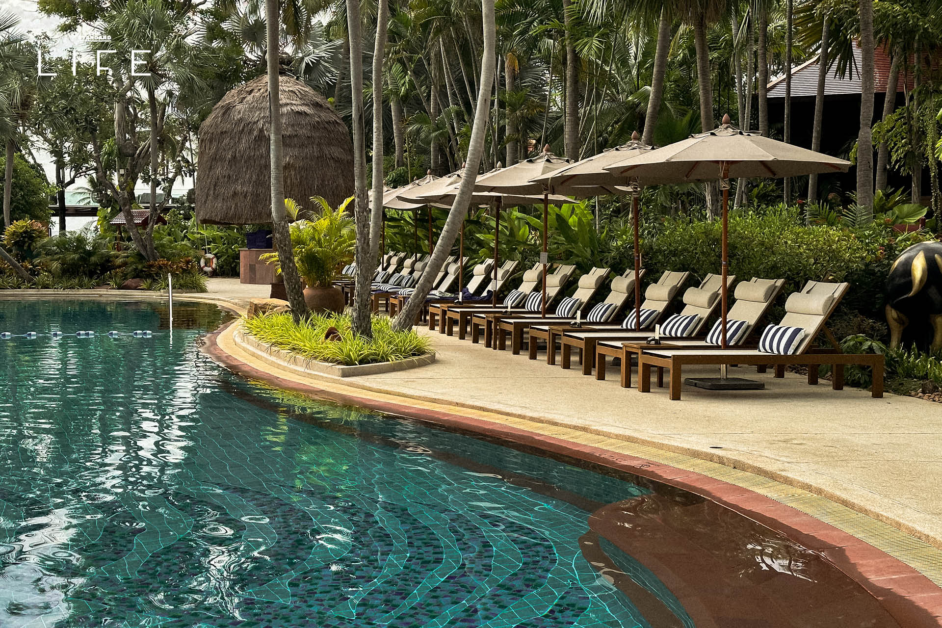 ภาพมุมกว้างของ Anantara Hua Hin Resort แสดงให้เห็นสระว่ายน้ำและอาคารทรงไทยที่ได้รับการปรับปรุงใหม่ 21