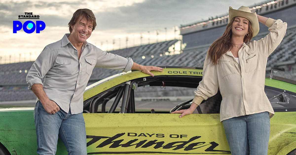 Tom Cruise และ Anne Hathaway ยืนโพสท่ากับรถแข่งสีเขียวในสนาม