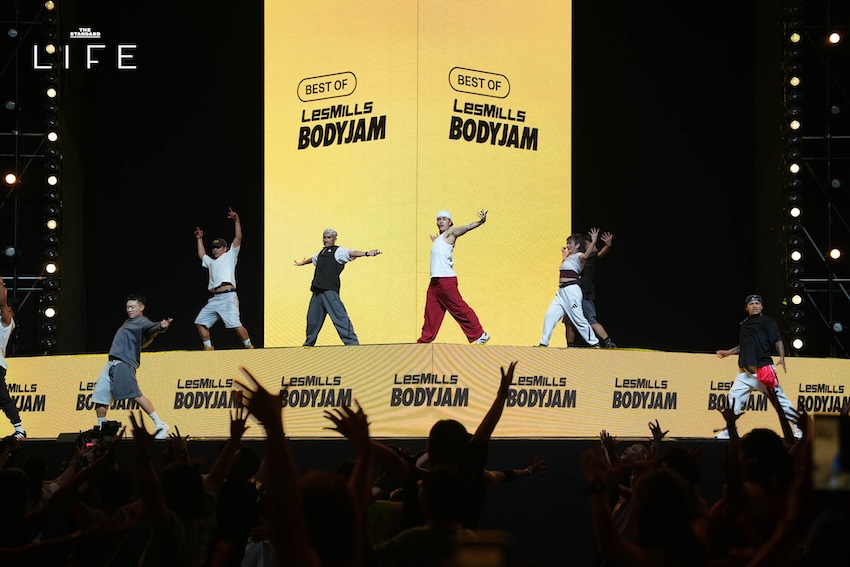 ภาพบรรยากาศงาน LES MILLS LIVE Bangkok 2026 x adidas ที่มีผู้คนจำนวนมากกำลังออกกำลังกายในฮอลล์ขนาดใหญ่ 6