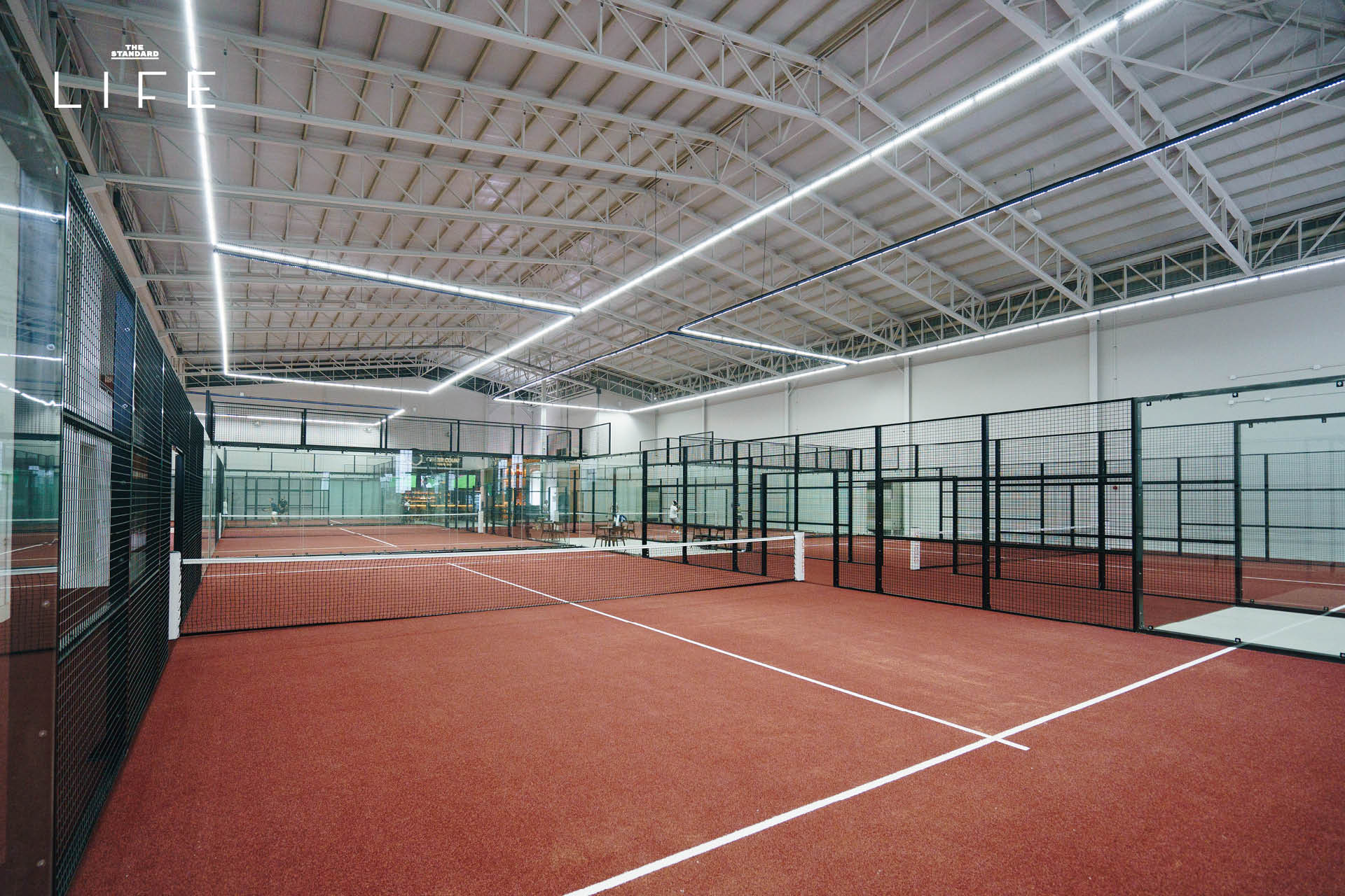 ภาพผู้คนกำลังเล่นกีฬา Padel ในคอร์ตกระจก 8