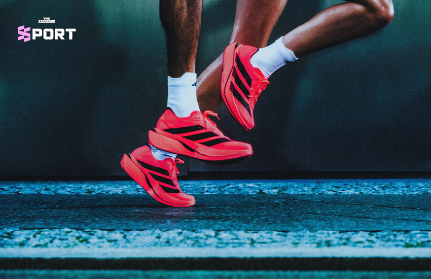 รองเท้าวิ่ง adidas Adizero Adios Pro 5 สีขาวส้ม วางอยู่บนพื้น 1