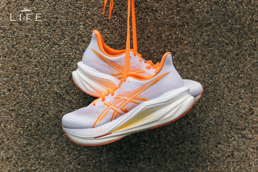 รองเท้าวิ่ง ASICS SONICBLAST 2 สีขาว-ส้ม วางอยู่บนพื้น 1