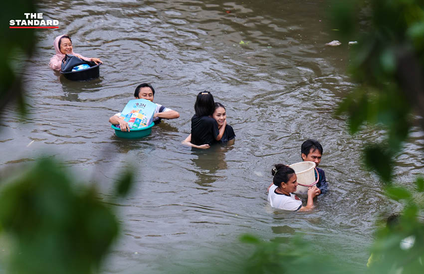 ภาพประชาชนเดินลุยน้ำท่วมสูงในชุมชนบางกะปิ ถนนและบ้านเรือนถูกน้ำท่วมขัง 13