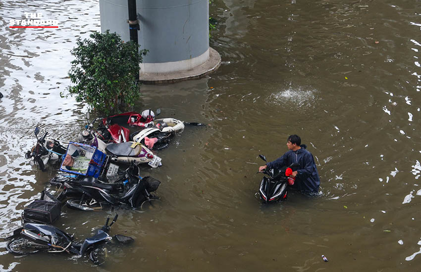 ภาพประชาชนเดินลุยน้ำท่วมสูงในชุมชนบางกะปิ ถนนและบ้านเรือนถูกน้ำท่วมขัง 3