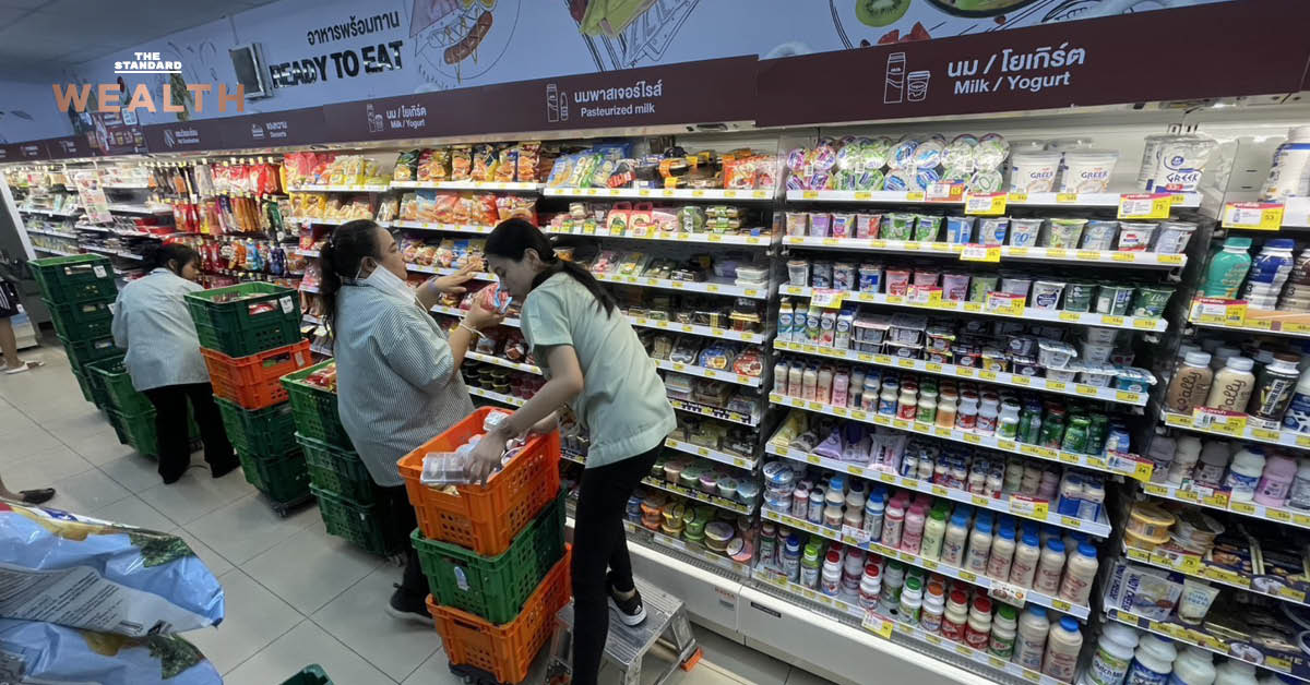 พนักงานกำลังเติมสินค้าจำเป็นบนชั้นวางภายในร้าน 7-Eleven เพื่อรองรับสถานการณ์ฝนตกและน้ำท่วม