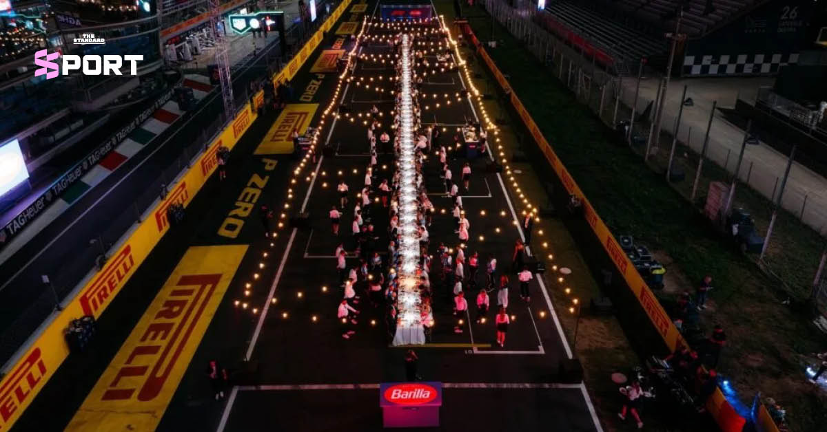 ภาพมุมกว้างของโต๊ะอาหารยาว 100 เมตร ที่จัดขึ้นบนทางตรงของสนามมอนซา มีผู้คนร่วมรับประทานอาหาร
