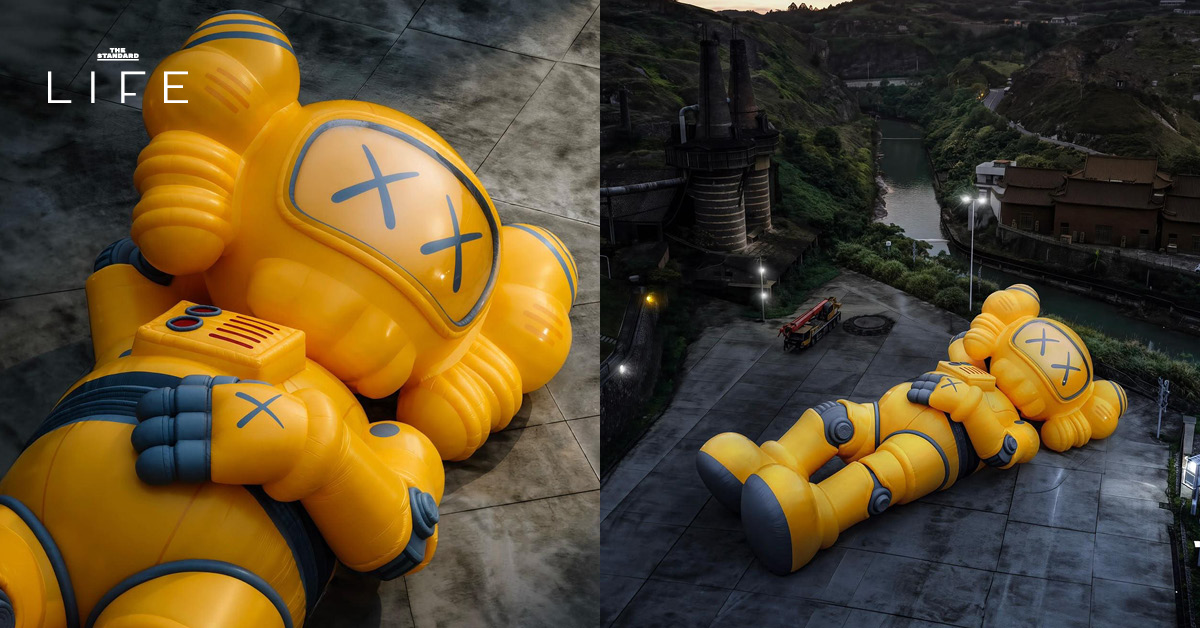 ประติมากรรม COMPANION สีเหลืองขนาดยักษ์ของ KAWS นอนอยู่ริมทะเลสาบ West Lake ที่หางโจว