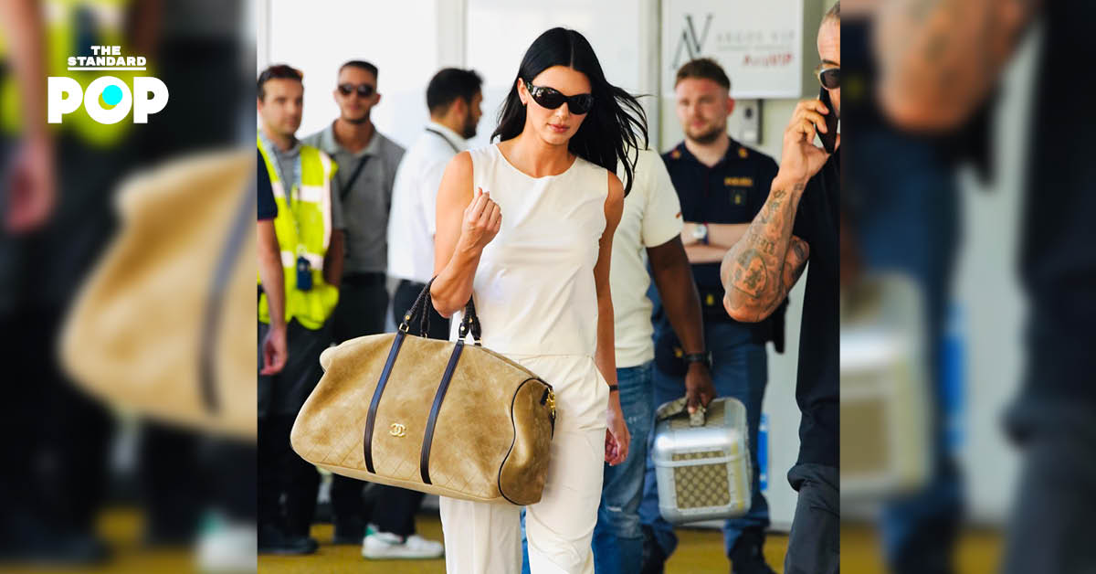Kendall Jenner ในชุดสีขาวถือกระเป๋าเดินทาง CHANEL Cruise 2027