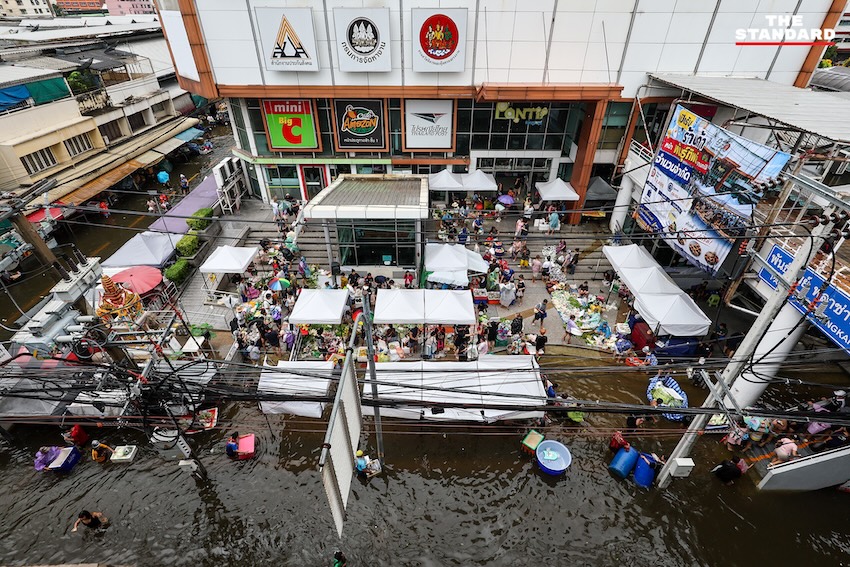 ภาพประชาชนเดินลุยน้ำท่วมขังในตลาดสด ย่านคลองจั่น บางกะปิ เพื่อจับจ่ายซื้ออาหารและสิ่งของจำเป็น 15