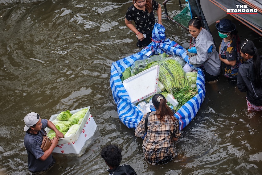 ภาพประชาชนเดินลุยน้ำท่วมขังในตลาดสด ย่านคลองจั่น บางกะปิ เพื่อจับจ่ายซื้ออาหารและสิ่งของจำเป็น 7