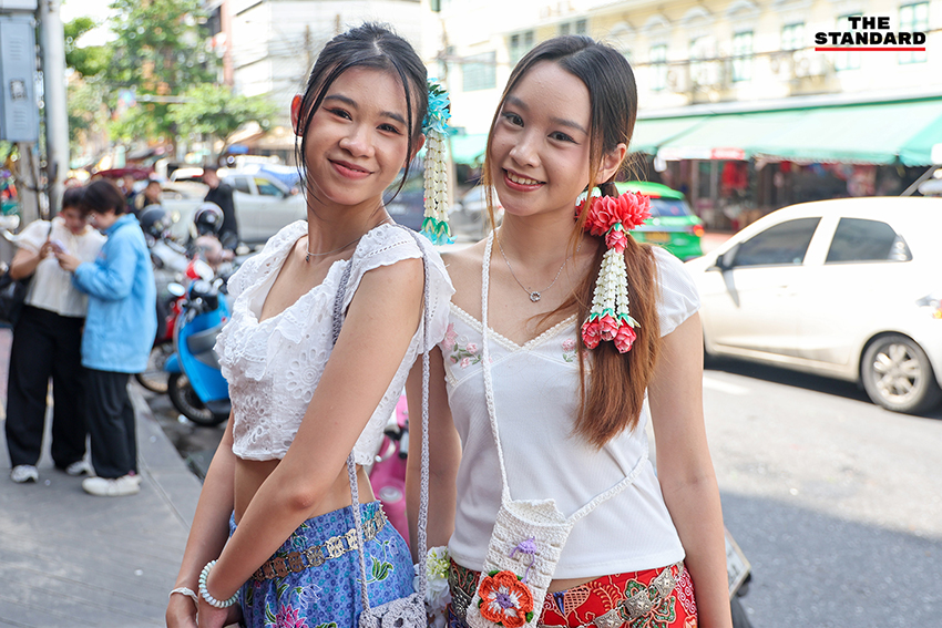ภาพผู้คนกำลังประดับมาลัยรัดเกล้าบนผมที่ปากคลองตลาด 12
