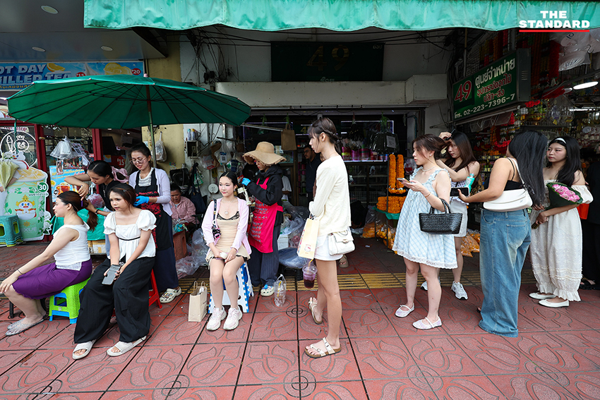 ภาพผู้คนกำลังประดับมาลัยรัดเกล้าบนผมที่ปากคลองตลาด 5