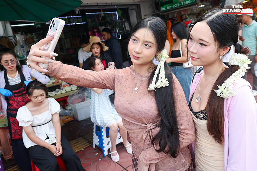 ภาพผู้คนกำลังประดับมาลัยรัดเกล้าบนผมที่ปากคลองตลาด 7