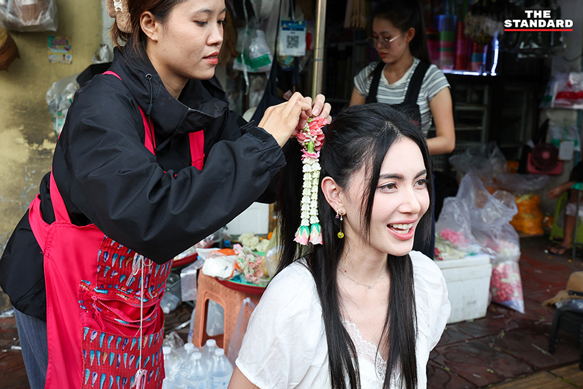 ภาพผู้คนกำลังประดับมาลัยรัดเกล้าบนผมที่ปากคลองตลาด 8