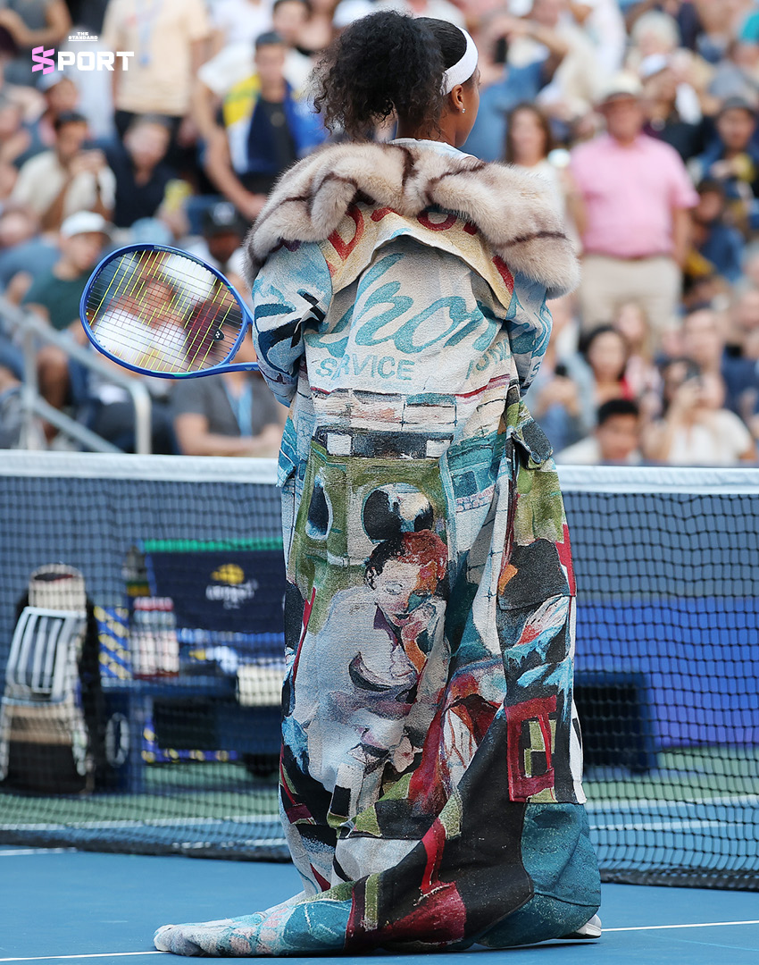นาโอมิ โอซากะ ในชุดโค้ตโอเวอร์ไซซ์มีฮู้ดและกระโปรงดีไซน์สะดุดตา เดินเข้าสู่คอร์ทเทนนิส 3