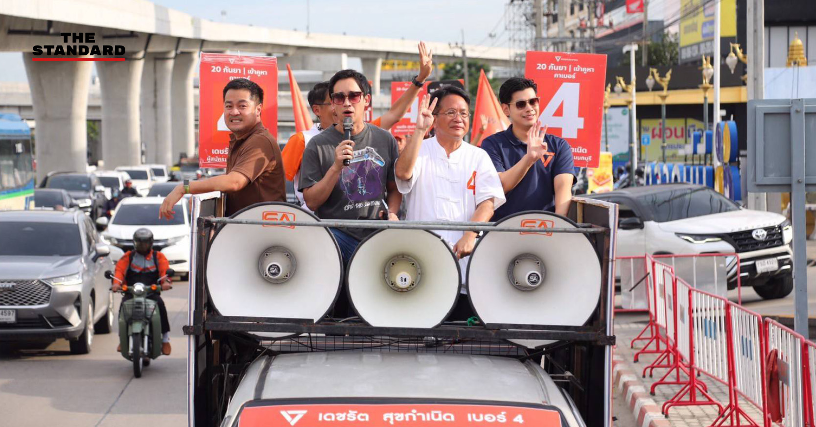 พิธา ลิ้มเจริญรัตน์ และ เดชรัต สุขกำเนิด บนรถแห่หาเสียง กำลังโบกมือทักทายประชาชนในจังหวัดนนทบุรี