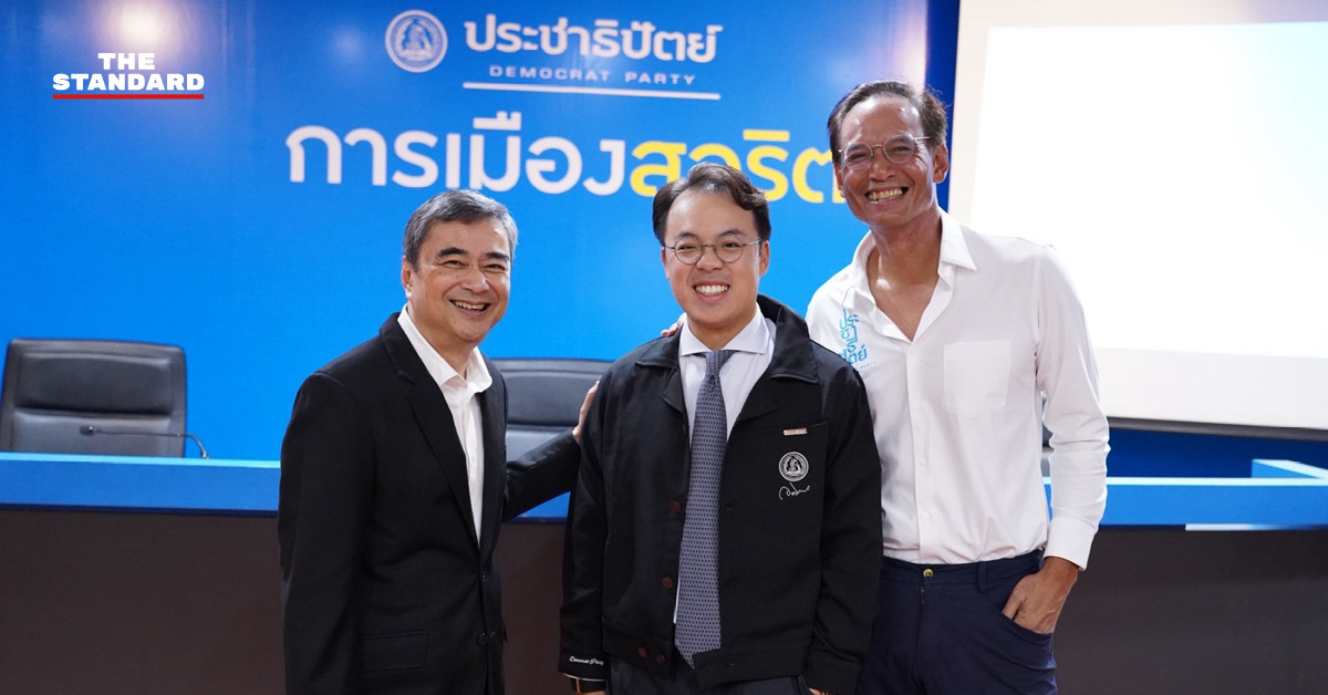 ปุ๊น ตรีรัตน์ ยืนถ่ายภาพร่วมกับอภิสิทธิ์ เวชชาชีวะ และกรณ์ จาติกวณิช ที่พรรคประชาธิปัตย์