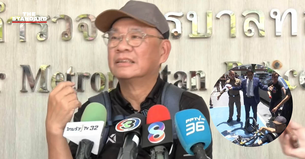 สมชัย ศรีสุทธิยากร ชายสวมสูทกางแขนกำลังให้สัมภาษณ์