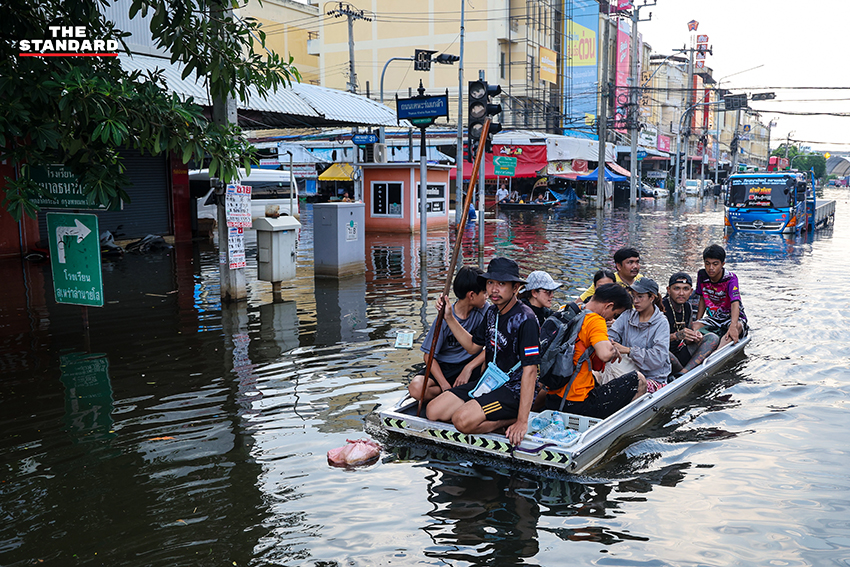 ภาพชาวบ้านในชุมชนเคหะร่มเกล้าใช้กะละมัง เรือเล็ก และรถกระบะสัญจรท่ามกลางน้ำท่วมสูง 12