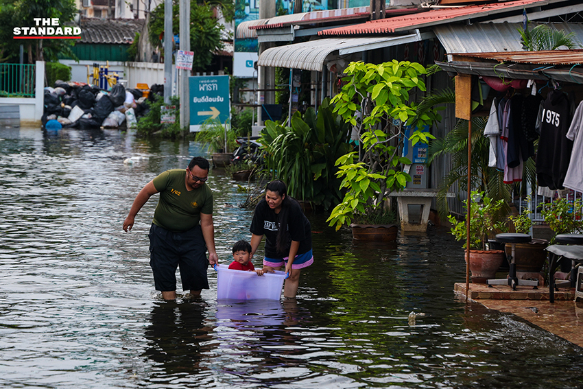 ภาพชาวบ้านในชุมชนเคหะร่มเกล้าใช้กะละมัง เรือเล็ก และรถกระบะสัญจรท่ามกลางน้ำท่วมสูง 14