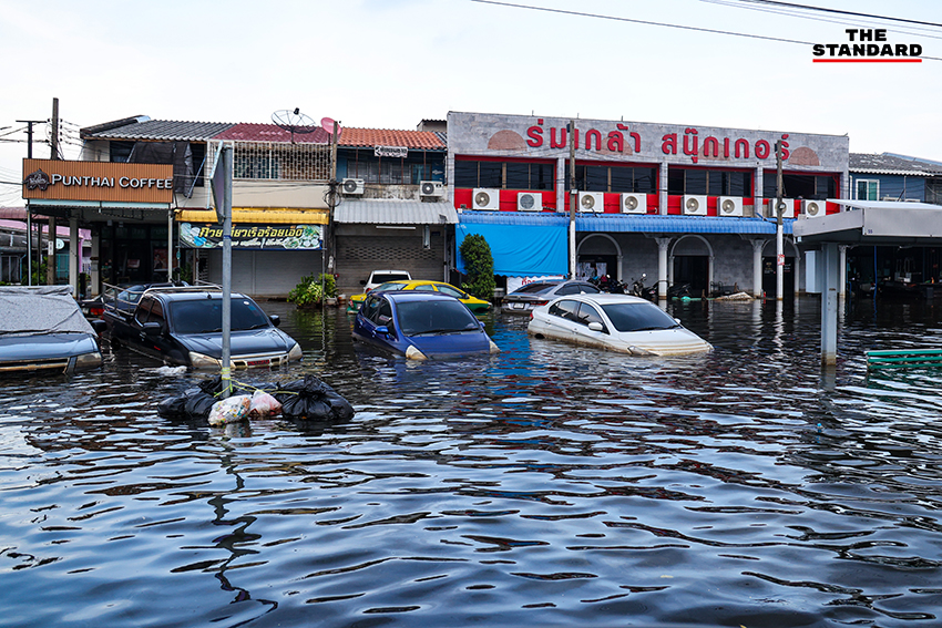 ภาพชาวบ้านในชุมชนเคหะร่มเกล้าใช้กะละมัง เรือเล็ก และรถกระบะสัญจรท่ามกลางน้ำท่วมสูง 15