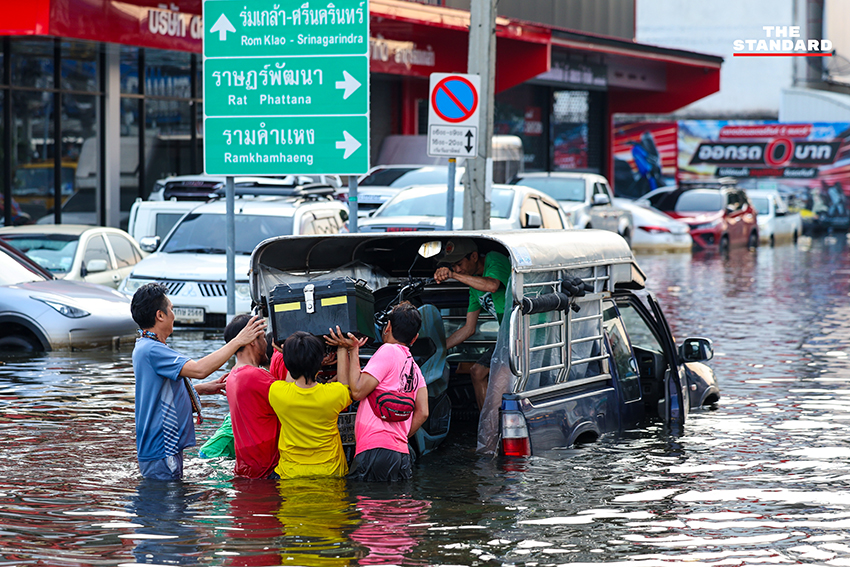 ภาพชาวบ้านในชุมชนเคหะร่มเกล้าใช้กะละมัง เรือเล็ก และรถกระบะสัญจรท่ามกลางน้ำท่วมสูง 17