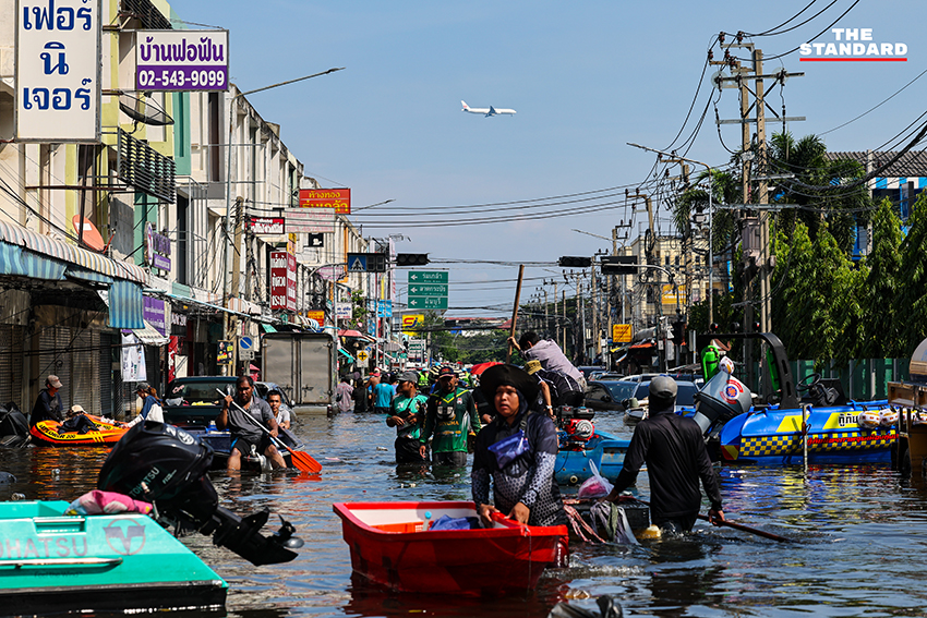 ภาพชาวบ้านในชุมชนเคหะร่มเกล้าใช้กะละมัง เรือเล็ก และรถกระบะสัญจรท่ามกลางน้ำท่วมสูง 19
