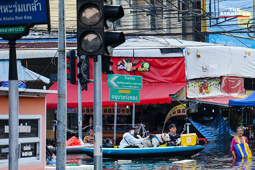 ภาพชาวบ้านในชุมชนเคหะร่มเกล้าใช้กะละมัง เรือเล็ก และรถกระบะสัญจรท่ามกลางน้ำท่วมสูง 3