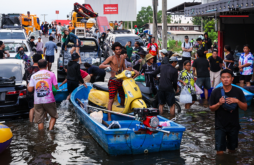 ภาพชาวบ้านในชุมชนเคหะร่มเกล้าใช้กะละมัง เรือเล็ก และรถกระบะสัญจรท่ามกลางน้ำท่วมสูง 4