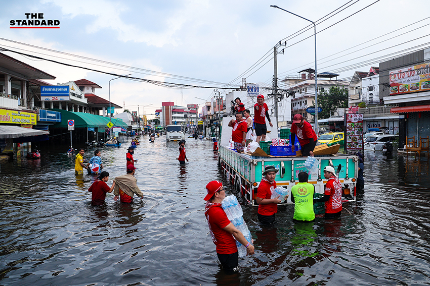 ภาพชาวบ้านในชุมชนเคหะร่มเกล้าใช้กะละมัง เรือเล็ก และรถกระบะสัญจรท่ามกลางน้ำท่วมสูง 5