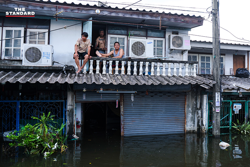 ภาพชาวบ้านในชุมชนเคหะร่มเกล้าใช้กะละมัง เรือเล็ก และรถกระบะสัญจรท่ามกลางน้ำท่วมสูง 7