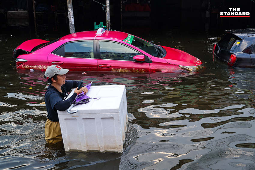 ภาพชาวบ้านในชุมชนเคหะร่มเกล้าใช้กะละมัง เรือเล็ก และรถกระบะสัญจรท่ามกลางน้ำท่วมสูง 9