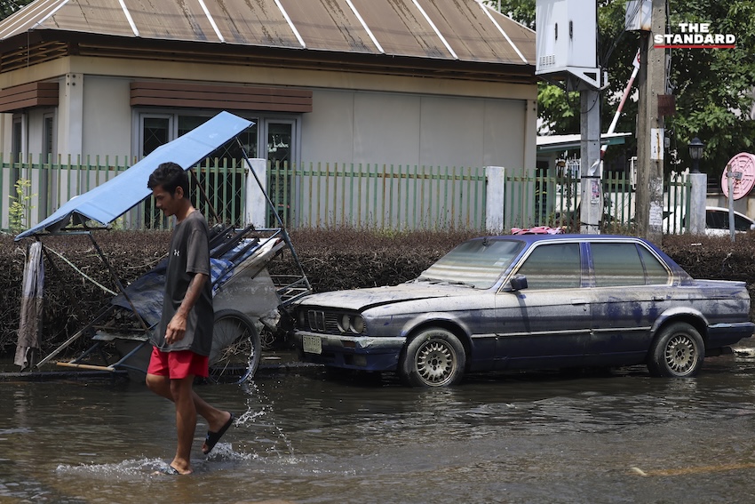 ประชาชนกำลังทำความสะอาดบ้านเรือนและถนนที่เต็มไปด้วยโคลนและขยะในเคหะร่มเกล้าหลังน้ำท่วม 10