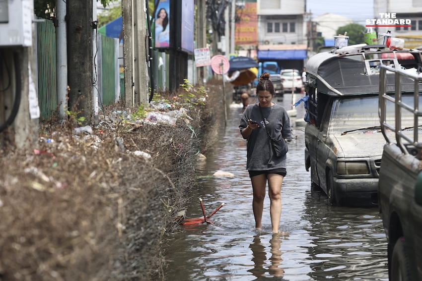 ประชาชนกำลังทำความสะอาดบ้านเรือนและถนนที่เต็มไปด้วยโคลนและขยะในเคหะร่มเกล้าหลังน้ำท่วม 11