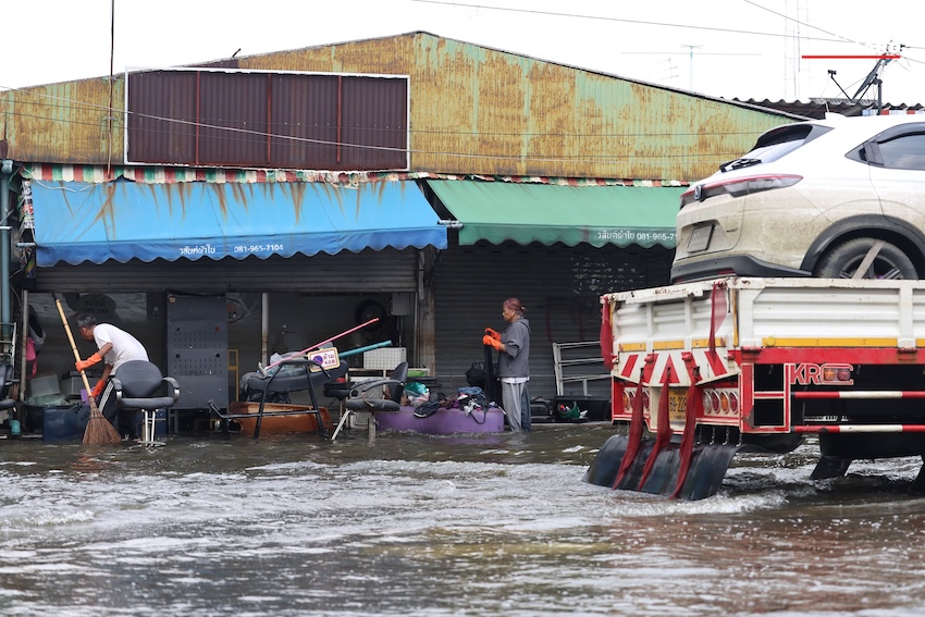 ประชาชนกำลังทำความสะอาดบ้านเรือนและถนนที่เต็มไปด้วยโคลนและขยะในเคหะร่มเกล้าหลังน้ำท่วม 20