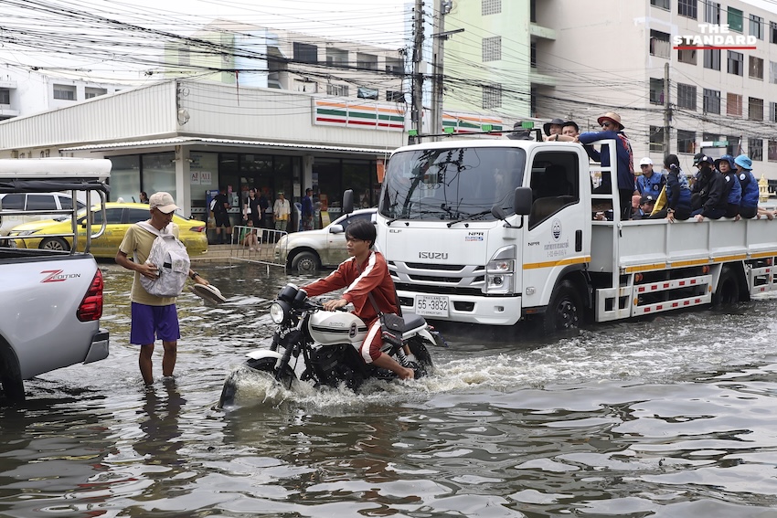ประชาชนกำลังทำความสะอาดบ้านเรือนและถนนที่เต็มไปด้วยโคลนและขยะในเคหะร่มเกล้าหลังน้ำท่วม 24