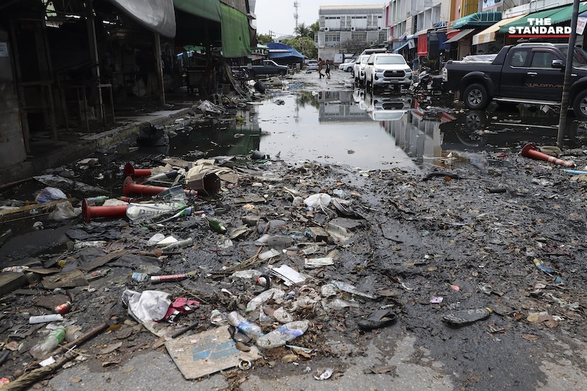 ประชาชนกำลังทำความสะอาดบ้านเรือนและถนนที่เต็มไปด้วยโคลนและขยะในเคหะร่มเกล้าหลังน้ำท่วม 25