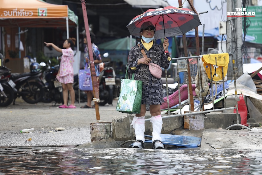 ประชาชนกำลังทำความสะอาดบ้านเรือนและถนนที่เต็มไปด้วยโคลนและขยะในเคหะร่มเกล้าหลังน้ำท่วม 5