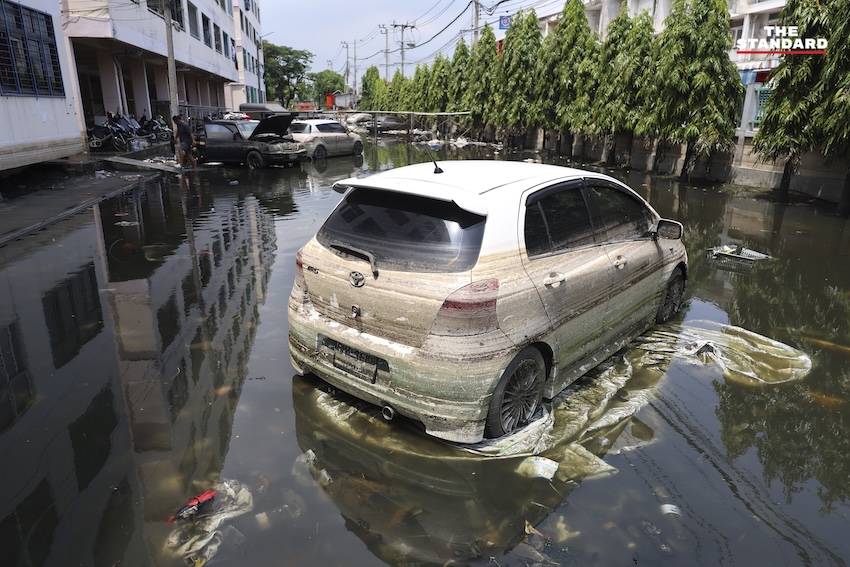 ประชาชนกำลังทำความสะอาดบ้านเรือนและถนนที่เต็มไปด้วยโคลนและขยะในเคหะร่มเกล้าหลังน้ำท่วม 6