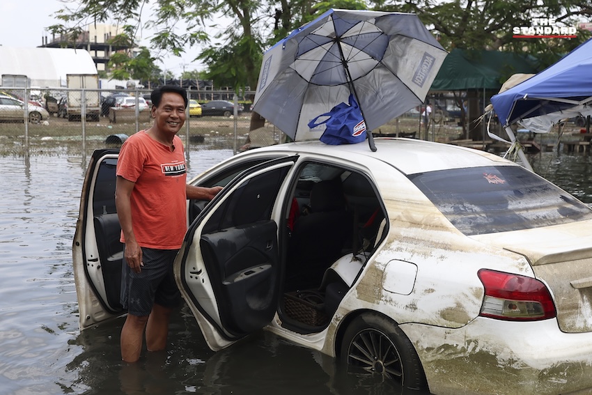 ประชาชนกำลังทำความสะอาดบ้านเรือนและถนนที่เต็มไปด้วยโคลนและขยะในเคหะร่มเกล้าหลังน้ำท่วม 7