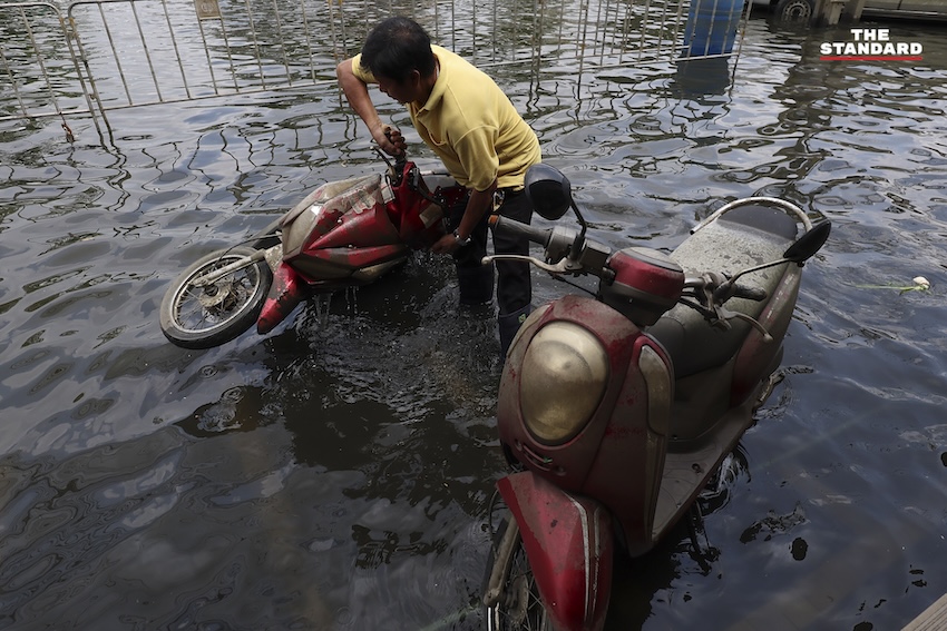 ประชาชนกำลังทำความสะอาดบ้านเรือนและถนนที่เต็มไปด้วยโคลนและขยะในเคหะร่มเกล้าหลังน้ำท่วม 8