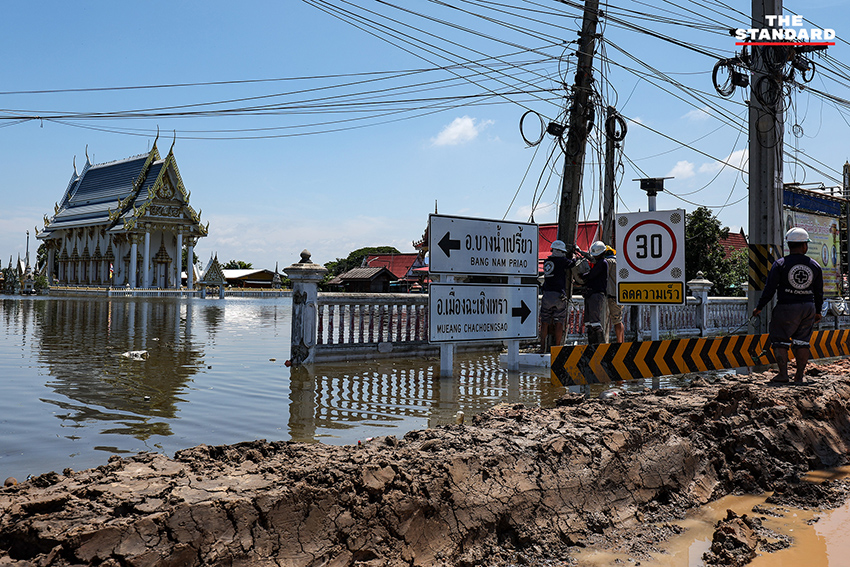 ภาพมุมกว้างแสดงสถานการณ์น้ำท่วมในอำเภอคลองเขื่อน จังหวัดฉะเชิงเทรา เจ้าหน้าที่เร่งเสริมแนวคันกั้นน้ำ และชาวบ้านใช้เรือสัญจร 10