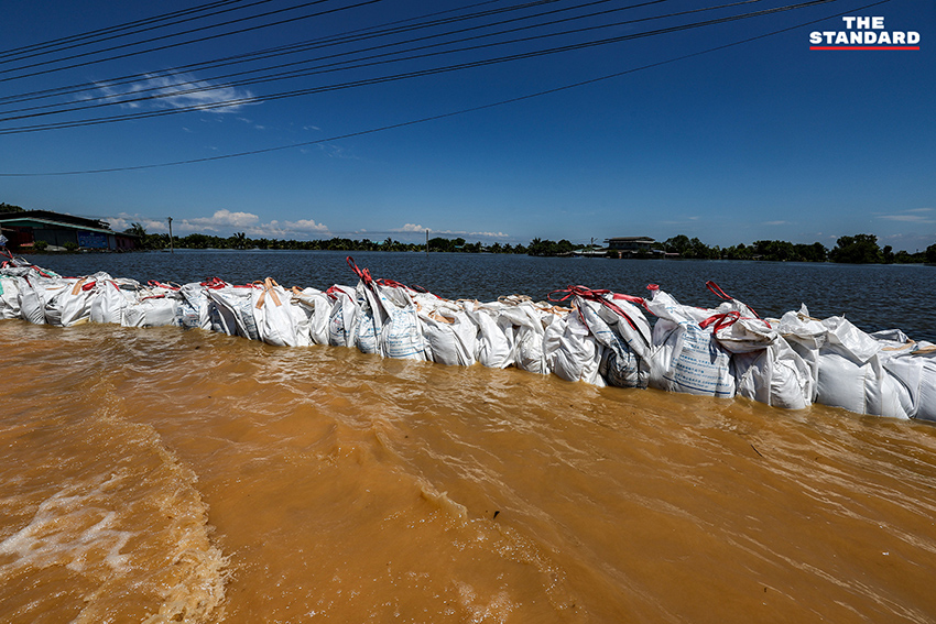 ภาพมุมกว้างแสดงสถานการณ์น้ำท่วมในอำเภอคลองเขื่อน จังหวัดฉะเชิงเทรา เจ้าหน้าที่เร่งเสริมแนวคันกั้นน้ำ และชาวบ้านใช้เรือสัญจร 5