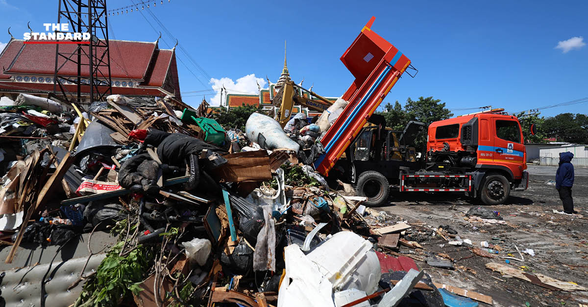 ภาพกองขยะน้ำท่วมจำนวนมากที่วัดบึงทองหลาง ขณะรถบรรทุกกำลังขนย้าย