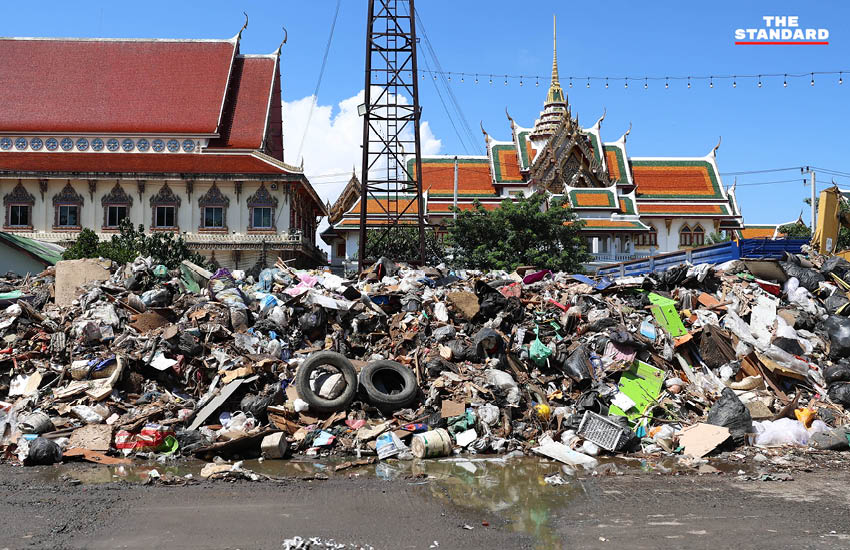 ภาพกองขยะน้ำท่วมจำนวนมากที่วัดบึงทองหลาง ขณะรถบรรทุกกำลังขนย้าย 1